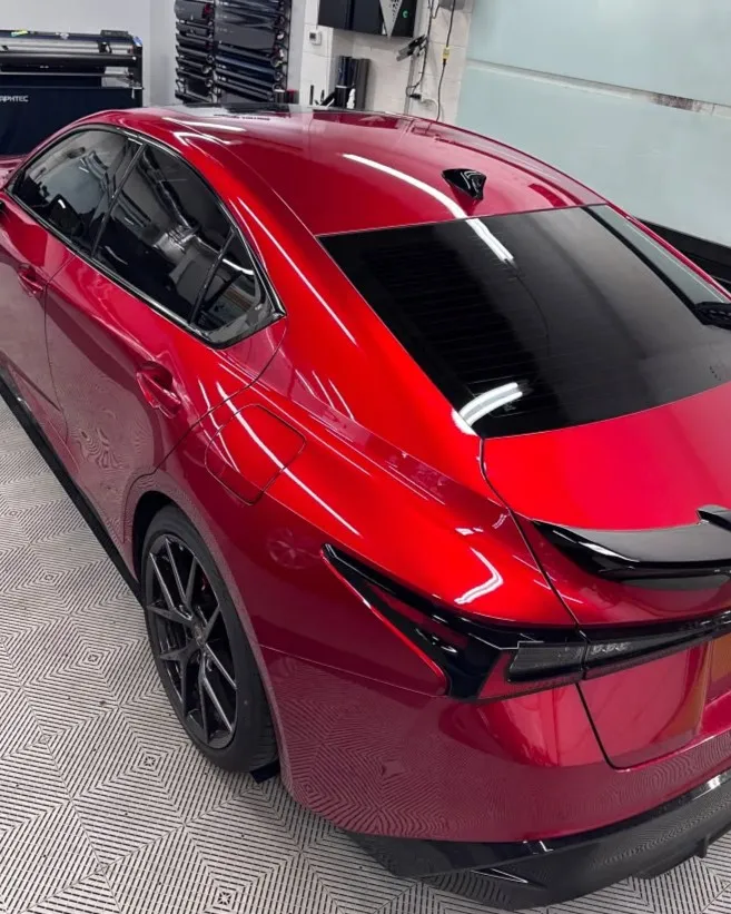 Red sedan with freshly tinted windows at Mario's Tint Shop