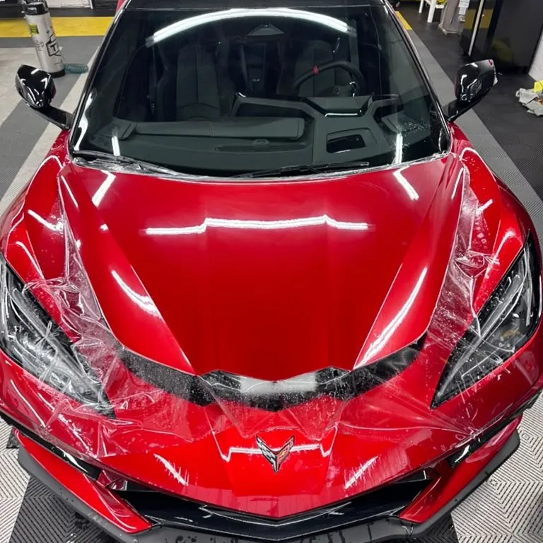 Paint protection film being applied to a red Corvette at Mario's Tint Shop