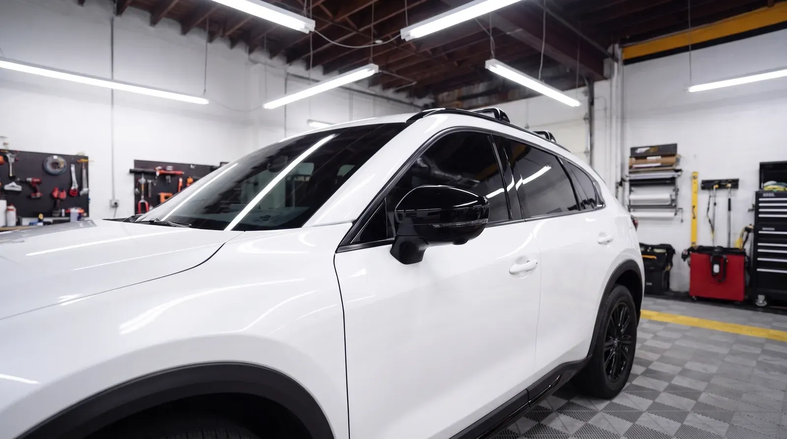White SUV with freshly installed window tint in the shop